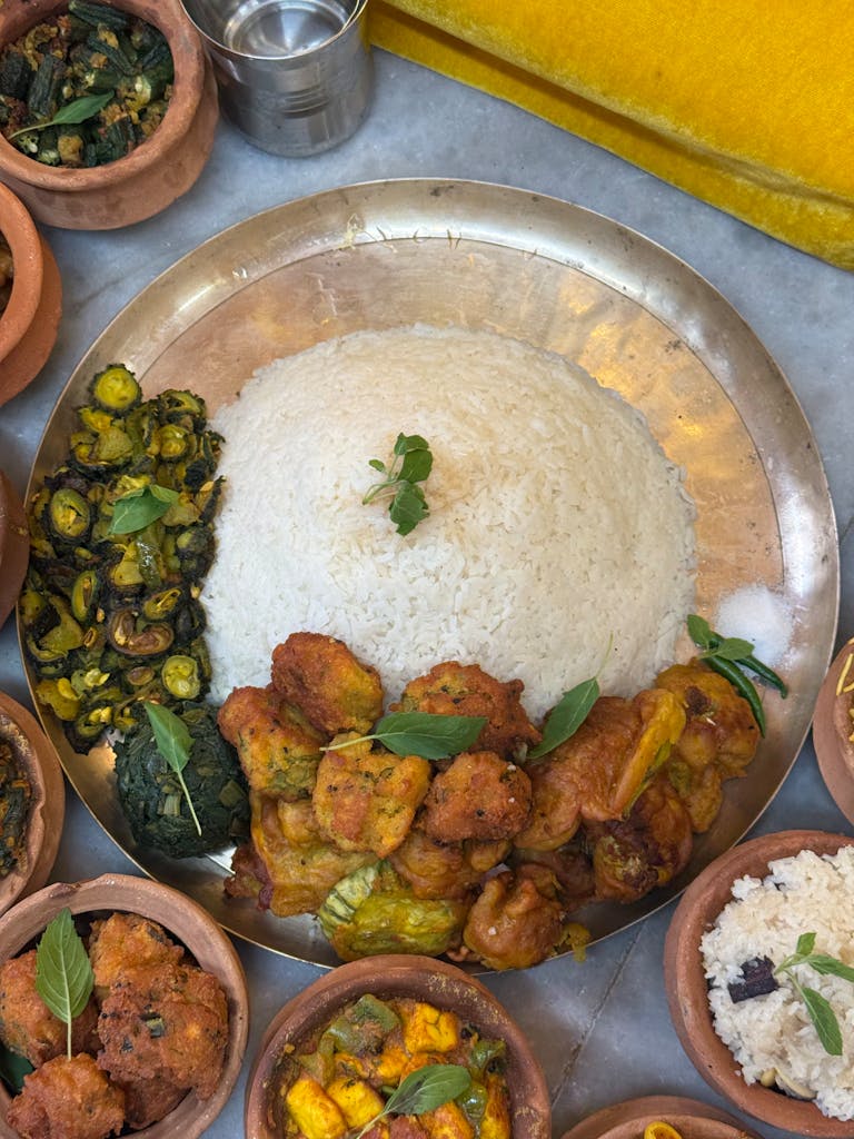 An appetizing traditional Nepali thali featuring rice, vegetables, and curry dishes arranged on a metal plate.