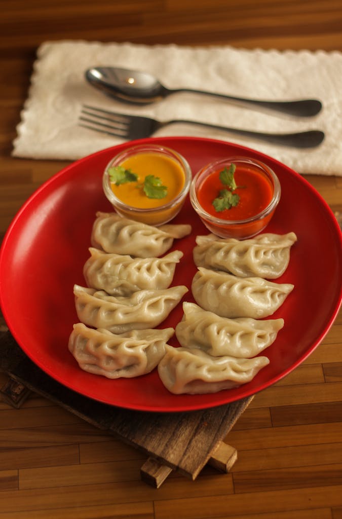 Delicious steamed dumplings with vibrant sauces, perfect for lunch or dinner.